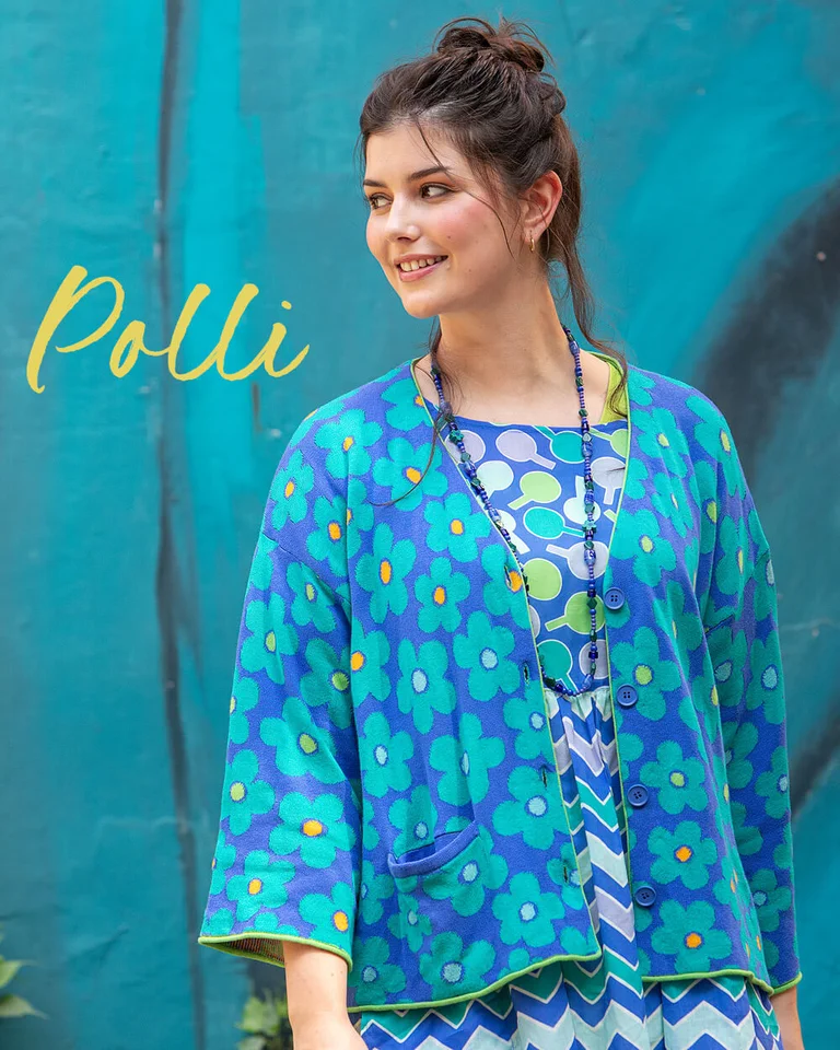 A woman wearing a floral-patterned blue cardigan from Gudrun Sjödén.