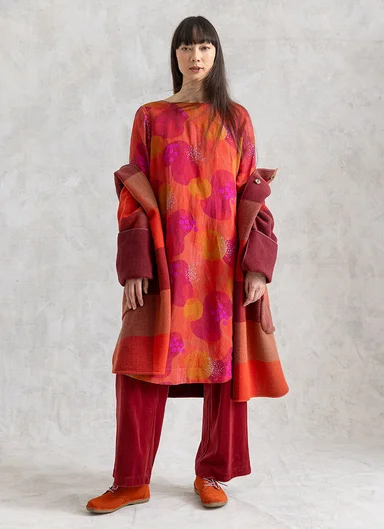 A woman wearing a patterned dress from Gudrun Sjödén.