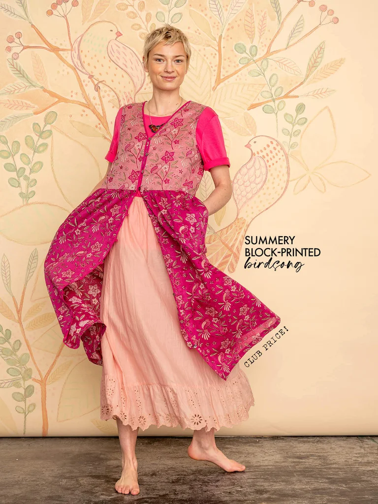 A woman wearing a pink floral dress from Gudrun Sjödén.