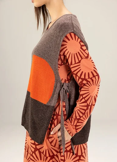 An upper body photographed from the side wearing a jersey top and a knit short-sleeved vest from Gudrun Sjödén.