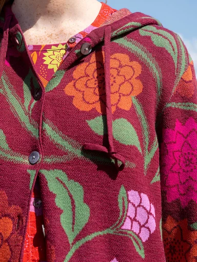 A woman wearing a floral knit cardigan from Gudrun Sjödén.