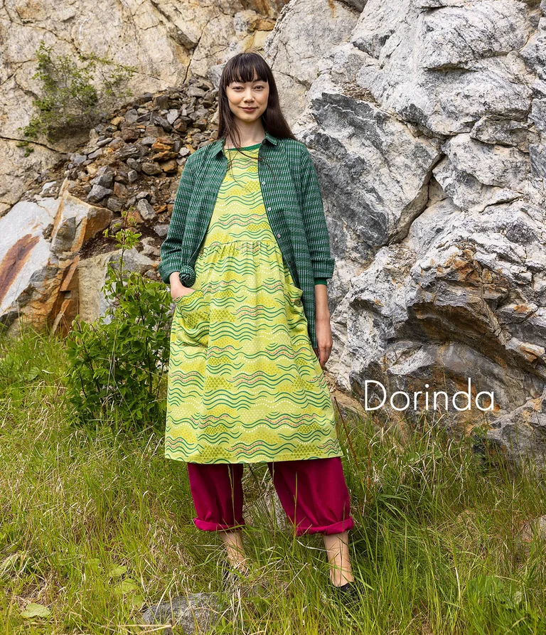 A woman wearing a patterned green dress from Gudrun Sjödén.