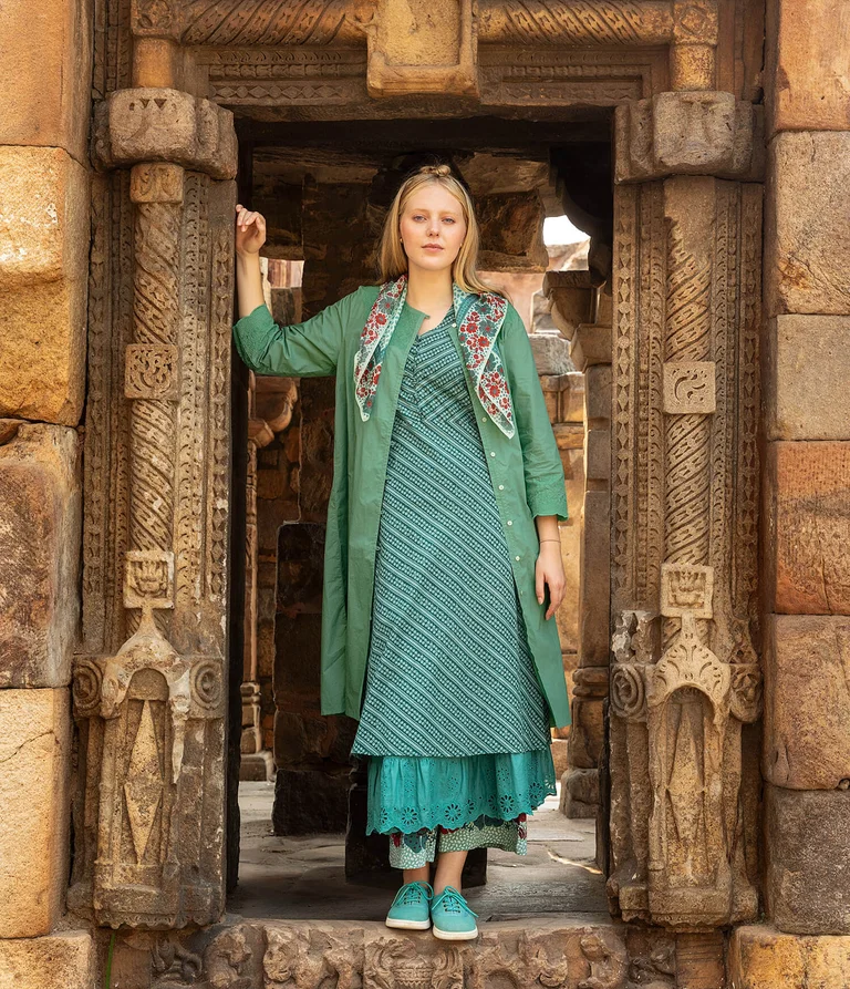 A woman wearing layers of blue-green clothing from Gudrun Sjödén.