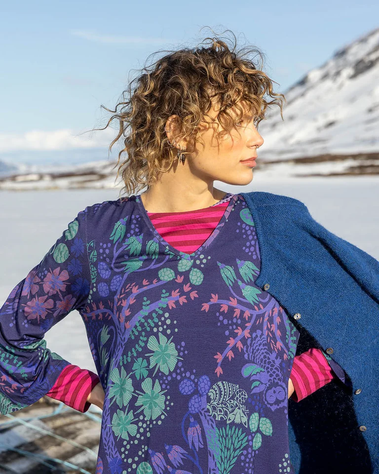 A close-up of a woman in a snowy landscape wearing layers of clothes from Gudrun Sjödén’s 2025 Christmas collection.