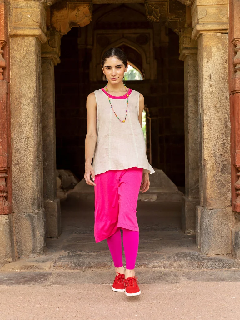A woman wearing a natural-colored tank top and pink dress from Gudrun Sjödén.