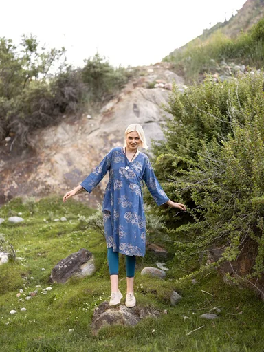 A woman wearing a patterned blue dress from Gudrun Sjödén.