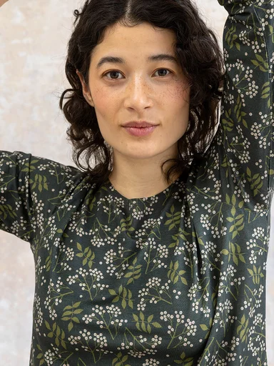 A woman wearing a patterned jersey top from Gudrun Sjödén.