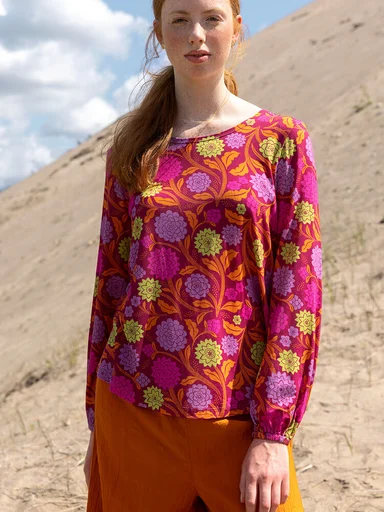 A woman wearing a floral-patterned top from Gudrun Sjödén.