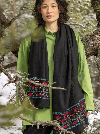 A woman wearing a black shawl from Gudrun Sjödén.