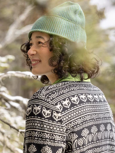 A woman wearing a patterned knit cardigan and hat from Gudrun Sjödén.