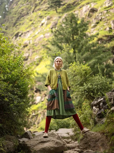 A woman wearing layers of green clothing from Gudrun Sjödén.