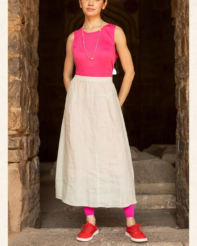 A woman wearing a pink tank top and natural-colored skirt from Gudrun Sjödén.