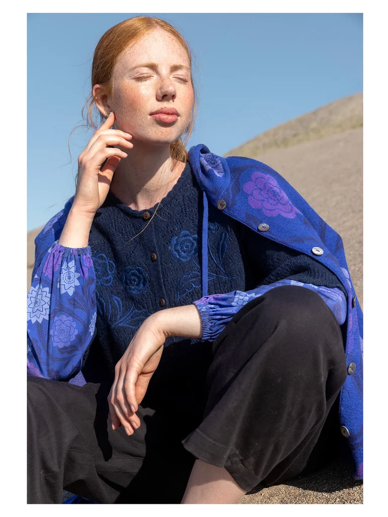 A woman wearing an embroidered cardigan, top and long cardigan from Gudrun Sjödén.