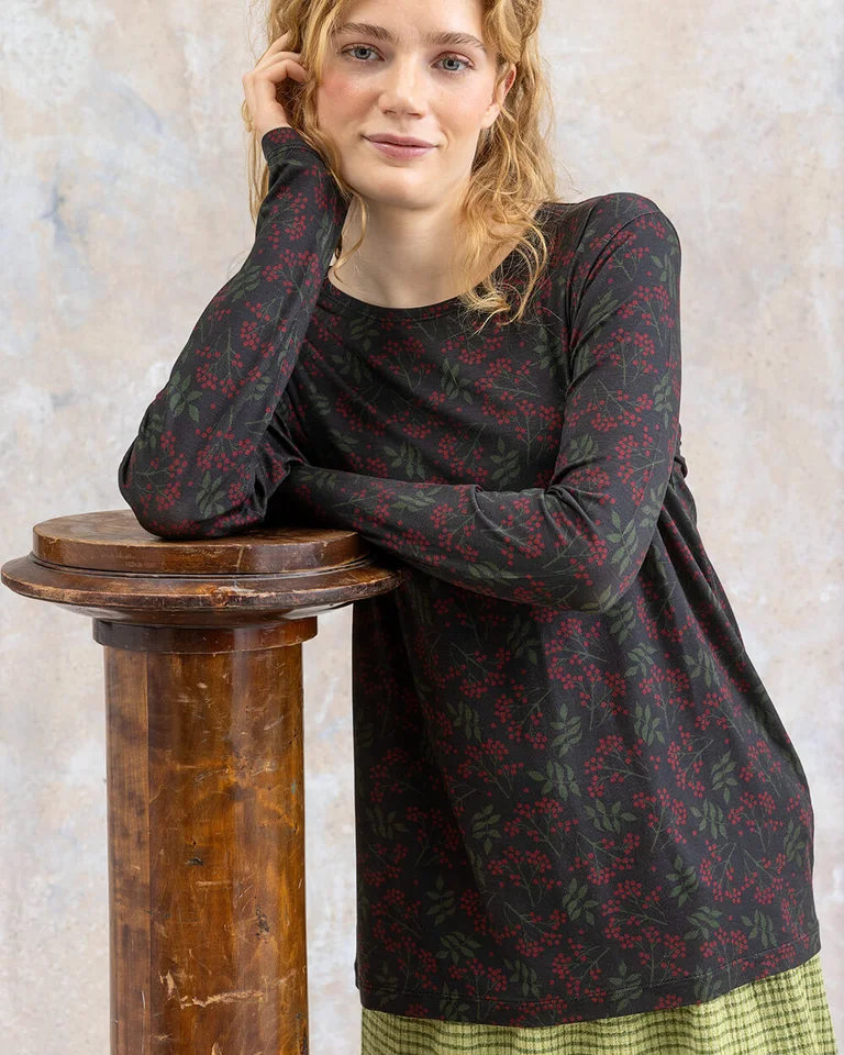 A woman wearing a patterned jersey top from Gudrun Sjödén.