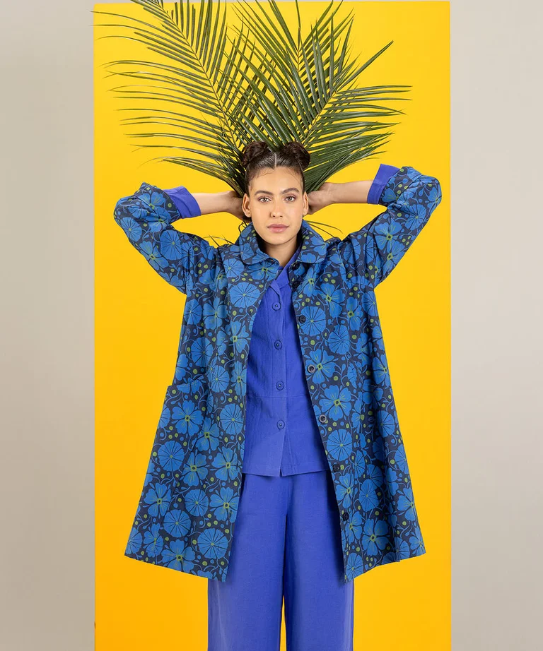 A woman wearing a patterned blue coat from Gudrun Sjödén.
