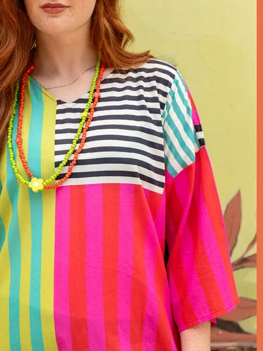 A closeup of an upper body wearing a striped dress from Gudrun Sjödén.