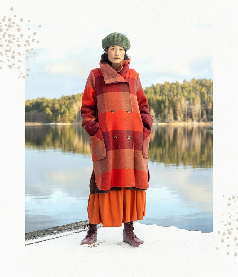 A woman wearing a checked coat from Gudrun Sjödén.