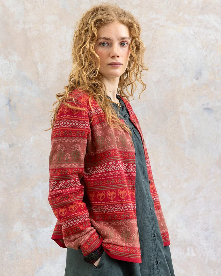 A woman wearing a patterned knit cardigan from Gudrun Sjödén.