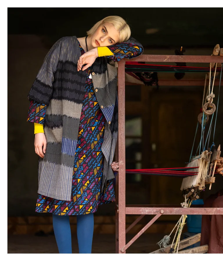 A woman wearing a patterned dress and an open dress from Gudrun Sjödén.