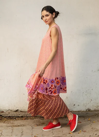 A woman wearing a patterned dress and skirt from Gudrun Sjödén.
