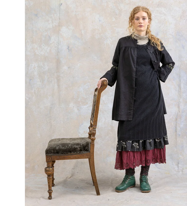 A woman wearing a black tunic and knit dress from Gudrun Sjödén.