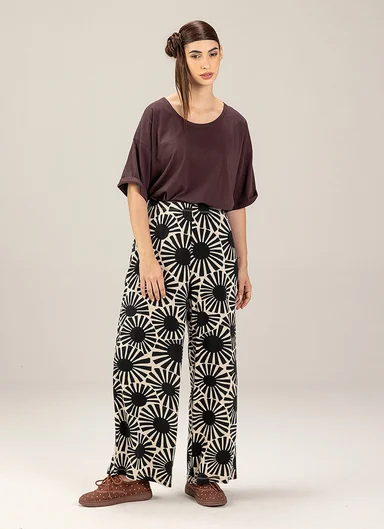 A woman wearing a brown top and a pair of patterned black and white pants from Gudrun Sjödén.