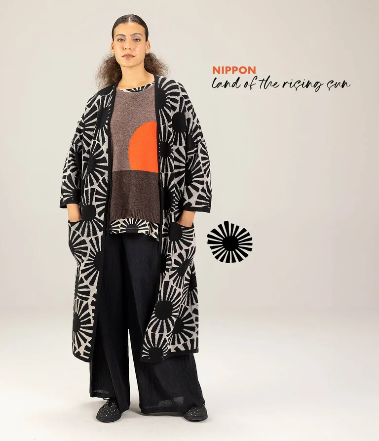 A woman wearing a black and white patterned long cardigan from Gudrun Sjödén.