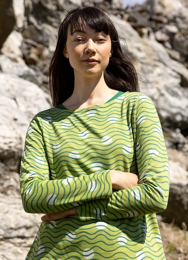 A woman wearing a green jersey top from Gudrun Sjödén.