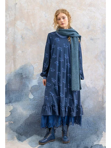 A woman wearing a patterned blue dress from Gudrun Sjödén.