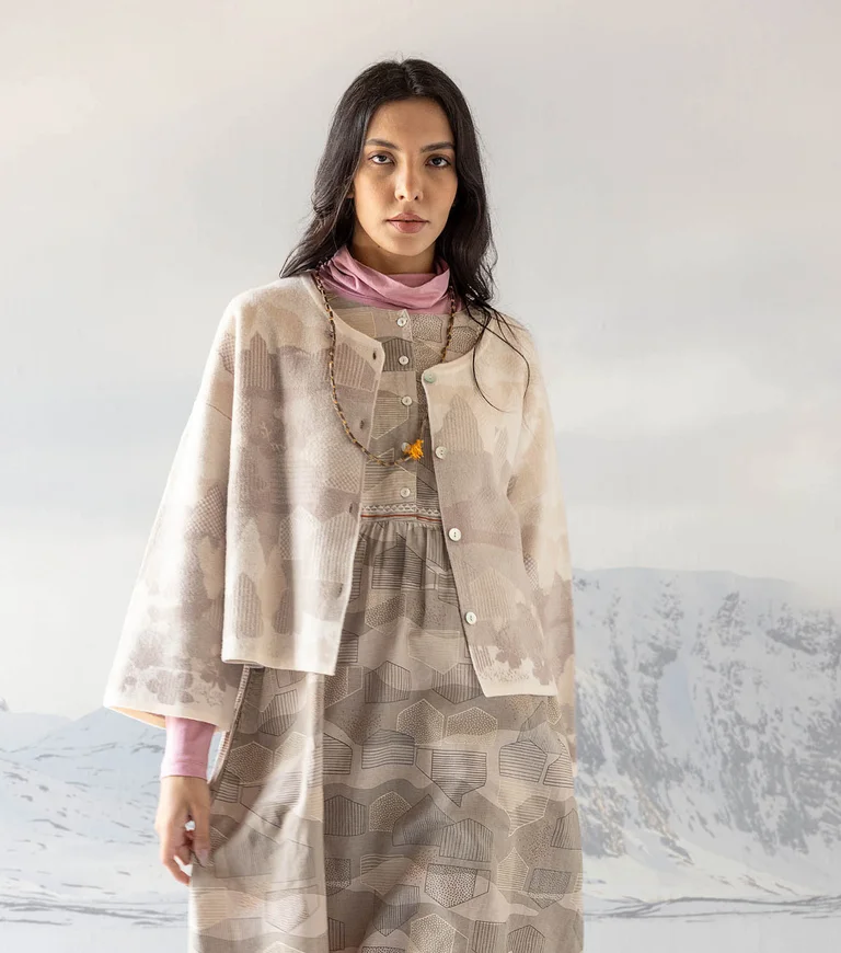 A collage with a snowy landscape, colourful houses and women wearing clothes from Gudrun Sjödén’s 2025 Christmas collection.