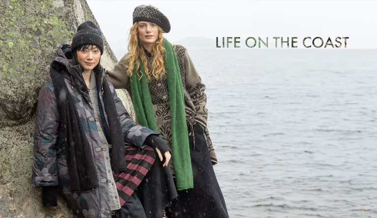 Two women wearing layers of clothing and accessories from Gudrun Sjödén’s 2025 winter collection.