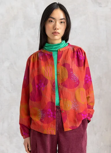 A woman wearing a patterned blouse from Gudrun Sjödén.