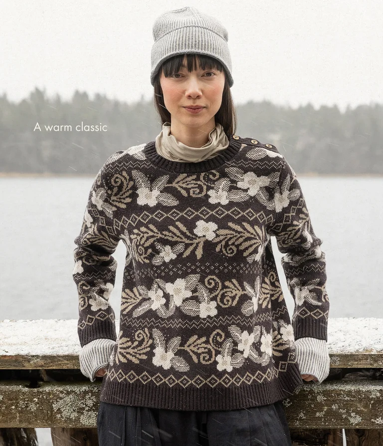 A woman wearing a floral knit sweater from Gudrun Sjödén.