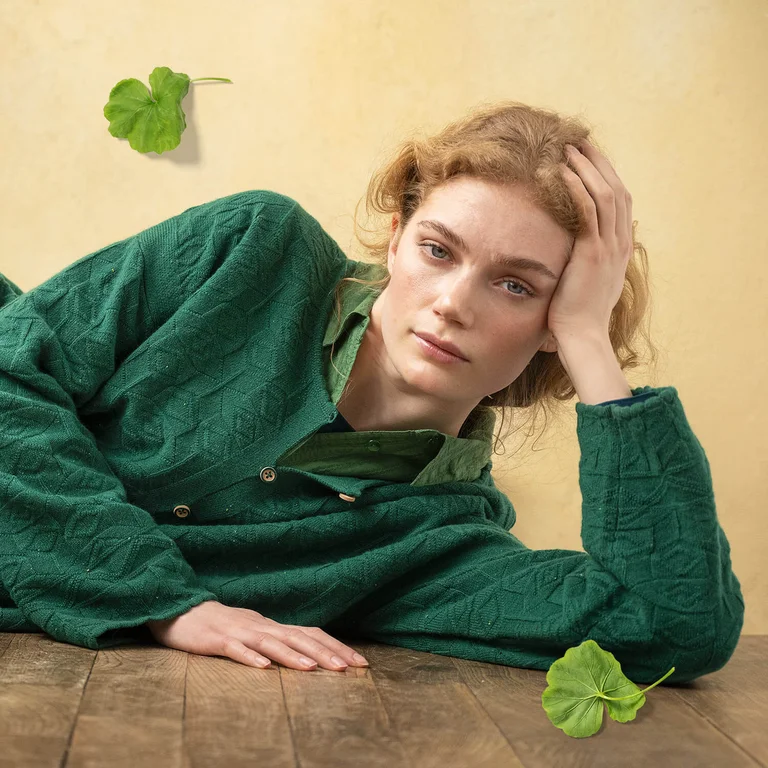 A woman wearing layers of green clothing.