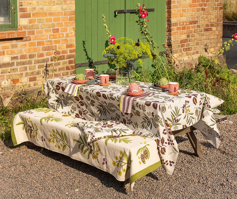 Een tafel met gedessineerd textiel uit de wooncollectie van Gudrun Sjödén. 