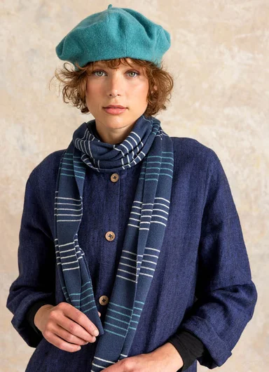 A woman with a beret and a large knitted scarf from Gudrun Sjödén.