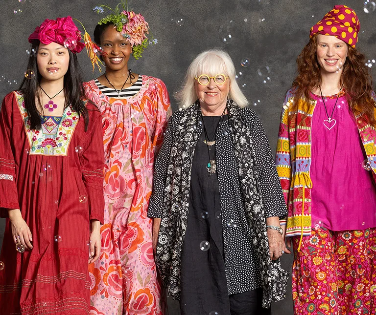 Four women wearing patterned creations from Gudrun Sjödén.