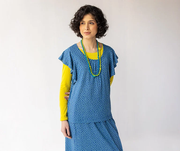 A woman wearing a blue dotted jersey top and matching skirt from Gudrun Sjödén.