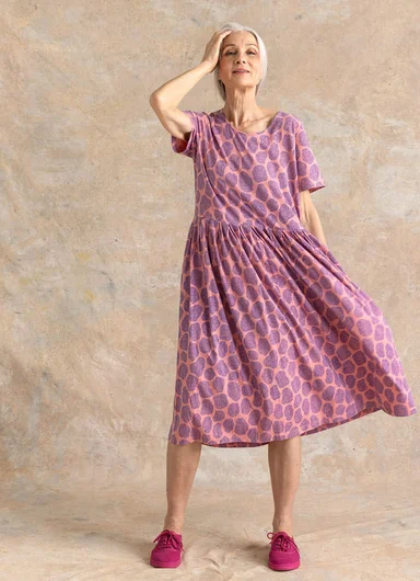 A woman wearing a red jersey dress from Gudrun Sjödén.