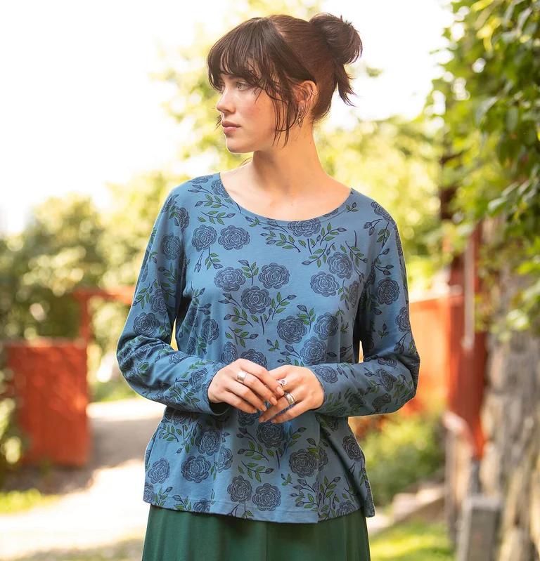 A woman wearing a rose patterned top from Gudrun Sjödén. 