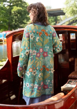 Vue arrière d'un cardigan à manches longues avec un motif floral et des boutons en bleu-vert. 
