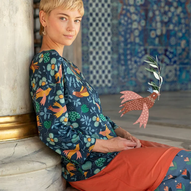 A woman wearing a patterned top from Gudrun Sjödén.  