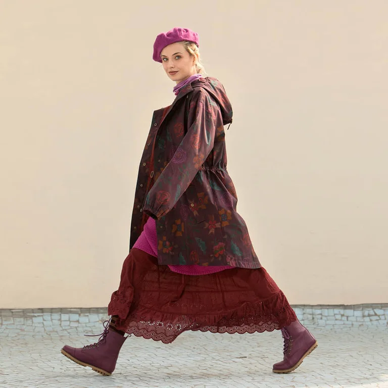 A woman walking, wearing a patterned parka from Gudrun Sjödén.