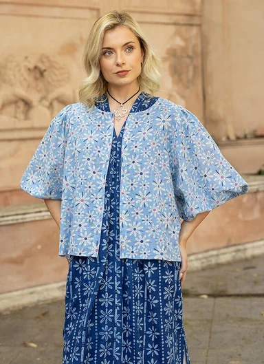 A woman wearing layers of woven patterned clothes in shades of blue from Gudrun Sjödén.