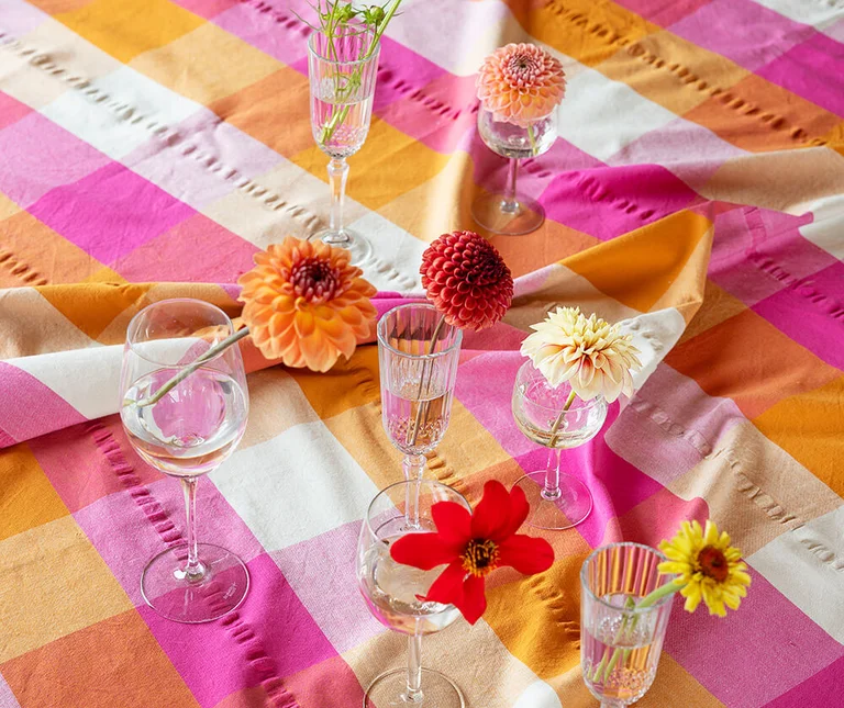 Small vases on a check tablecloth in shades of pink and terracotta 