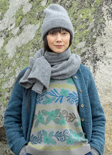 A woman wearing a knitted scarf and beanie from Gudrun Sjödén.