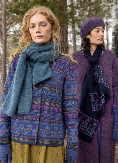 A woman standing in the forest wearing clothes from Gudrun Sjödén.