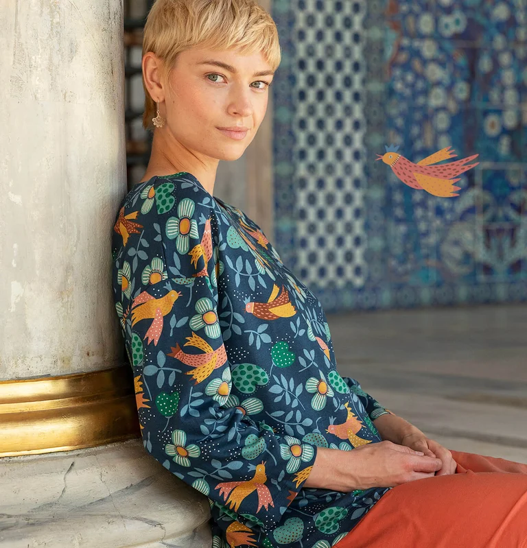 A woman wearing a patterned top from Gudrun Sjödén. 