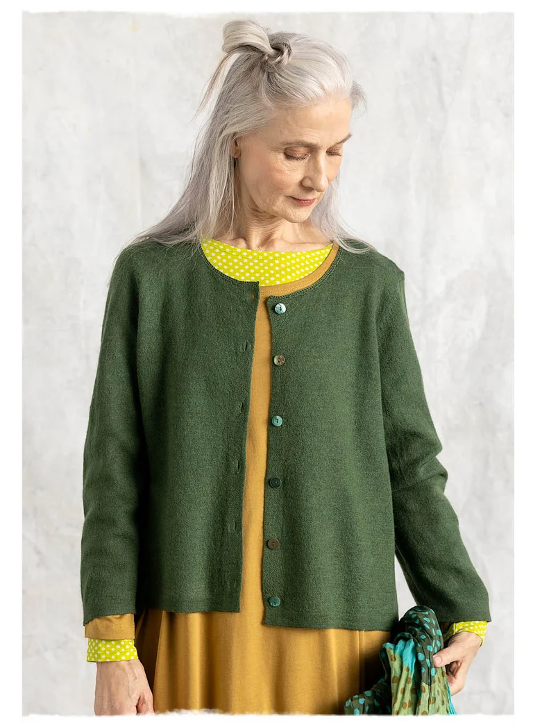 A woman wearing a green, knitted cardigan from Gudrun Sjödén.