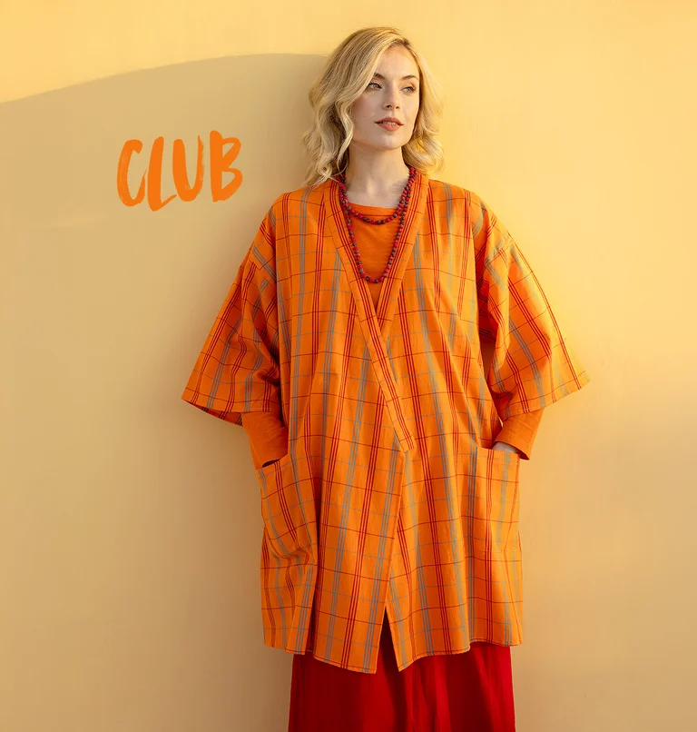 A woman wearing a checked orange kimono from Gudrun Sjödén.